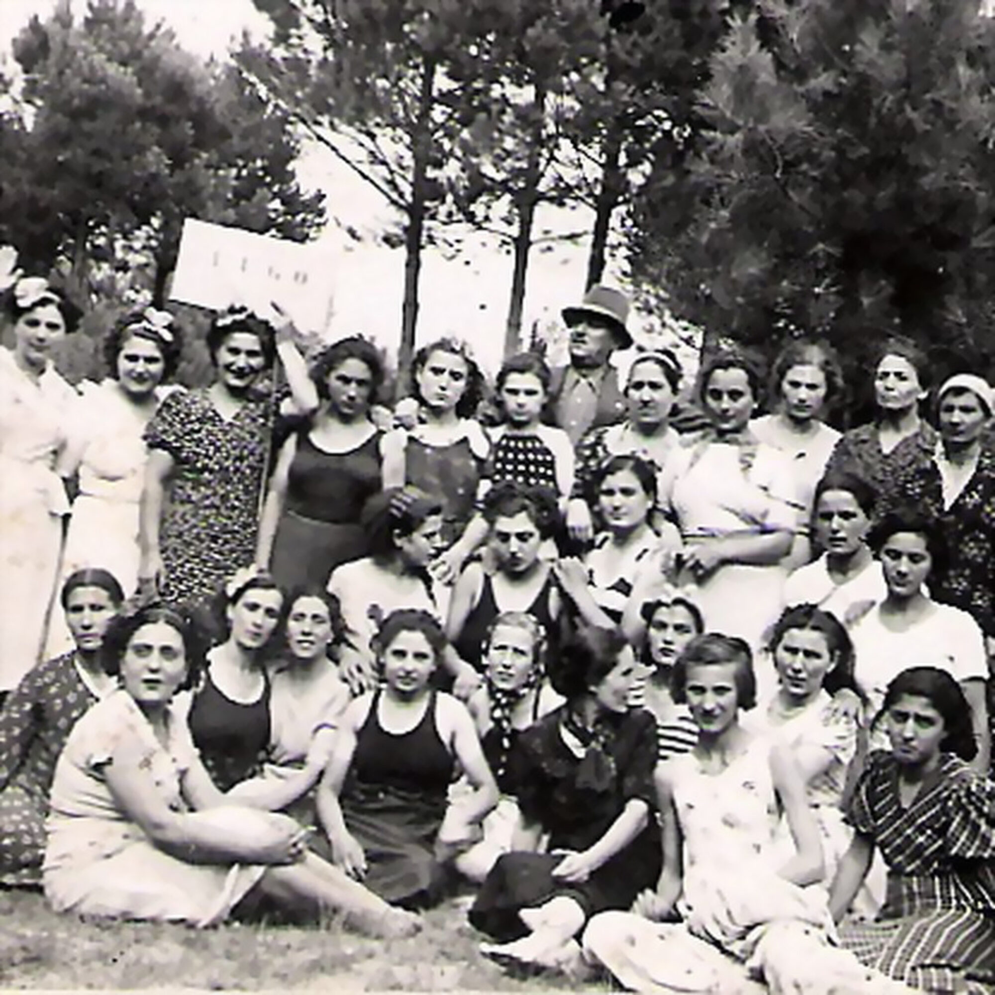Fotografia d'epoca in bianco e nero: un gruppo di lavoratrici di Minardi Piume in posa all'aperto