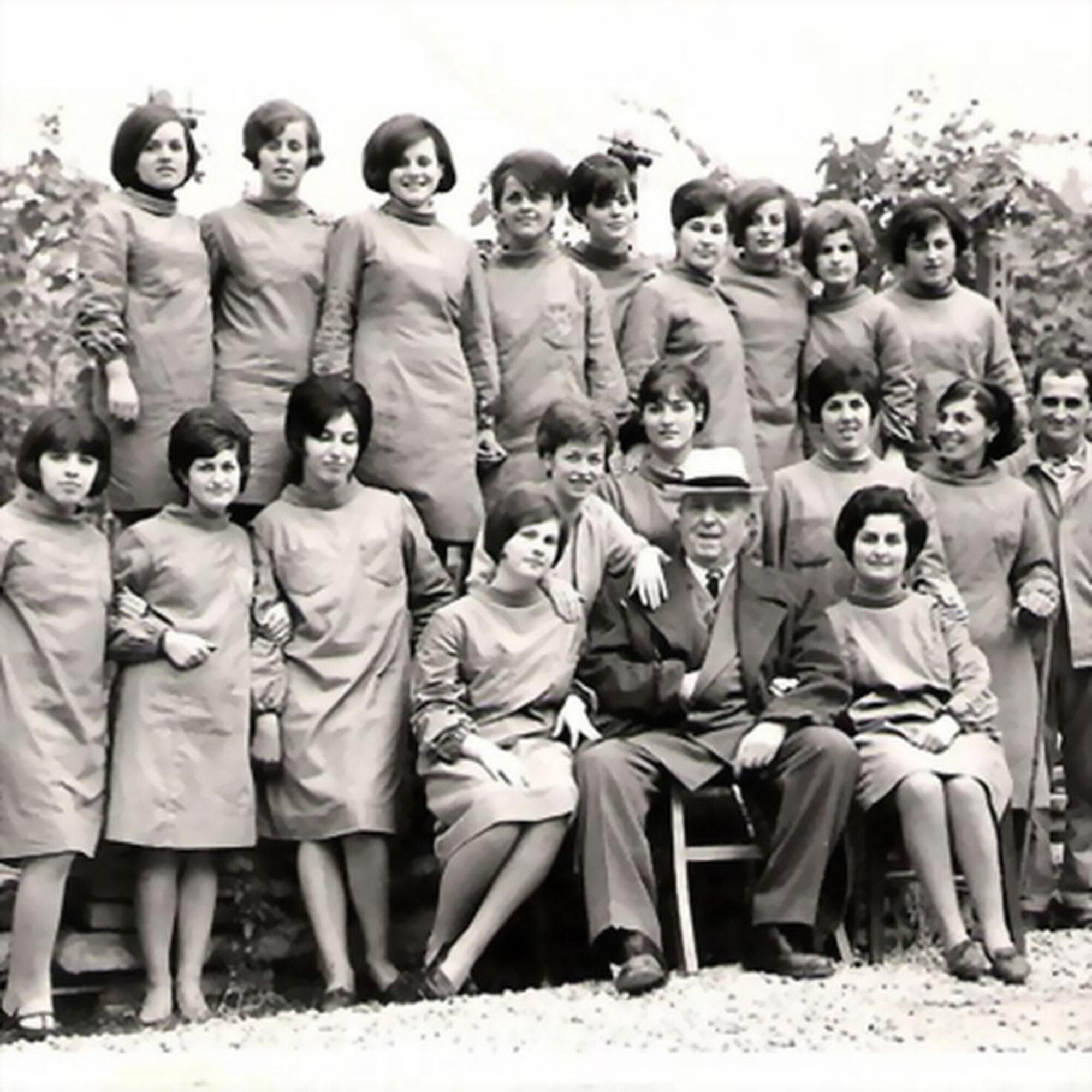 Fotografia d'epoca in bianco e nero: le lavoratrici di Minardi Piume in posa davanti allo stabilimento