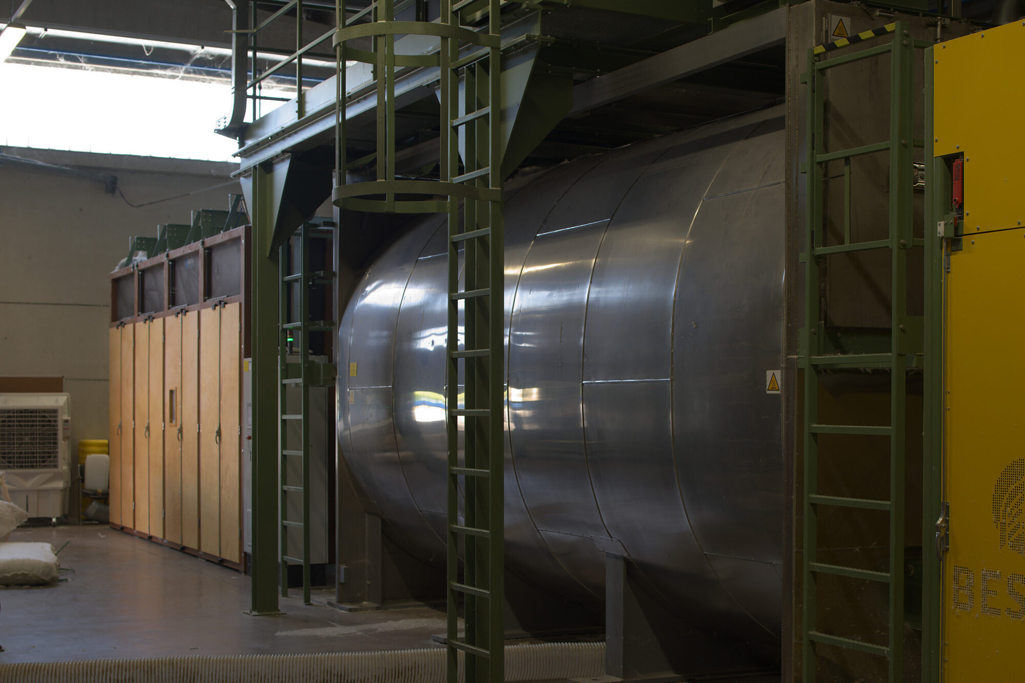Il grande cilindro inox della lavatrice WS9, con le cabine in legno della linea alle spalle