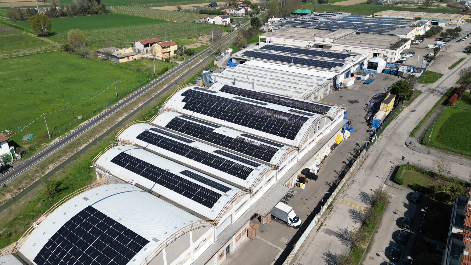 Lo stabilimento Minardi Piume di Lugo di Romagna visto dal drone: le sei volte a shed, la campagna e il tetto fotovoltaico